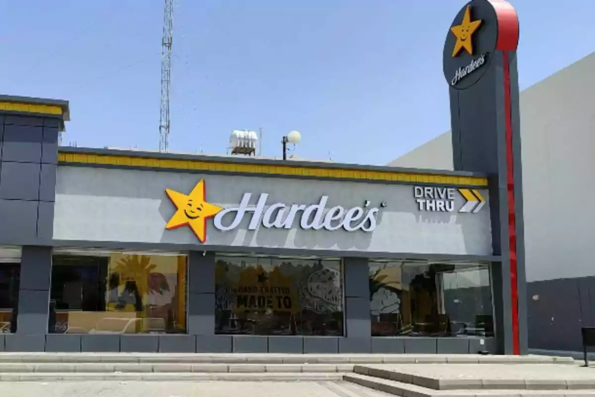 Frente de un restaurante de comida rápida con un letrero grande y una estrella amarilla sonriente. Frente de un restaurante de comida rápida con un letrero grande y una estrella amarilla sonriente.