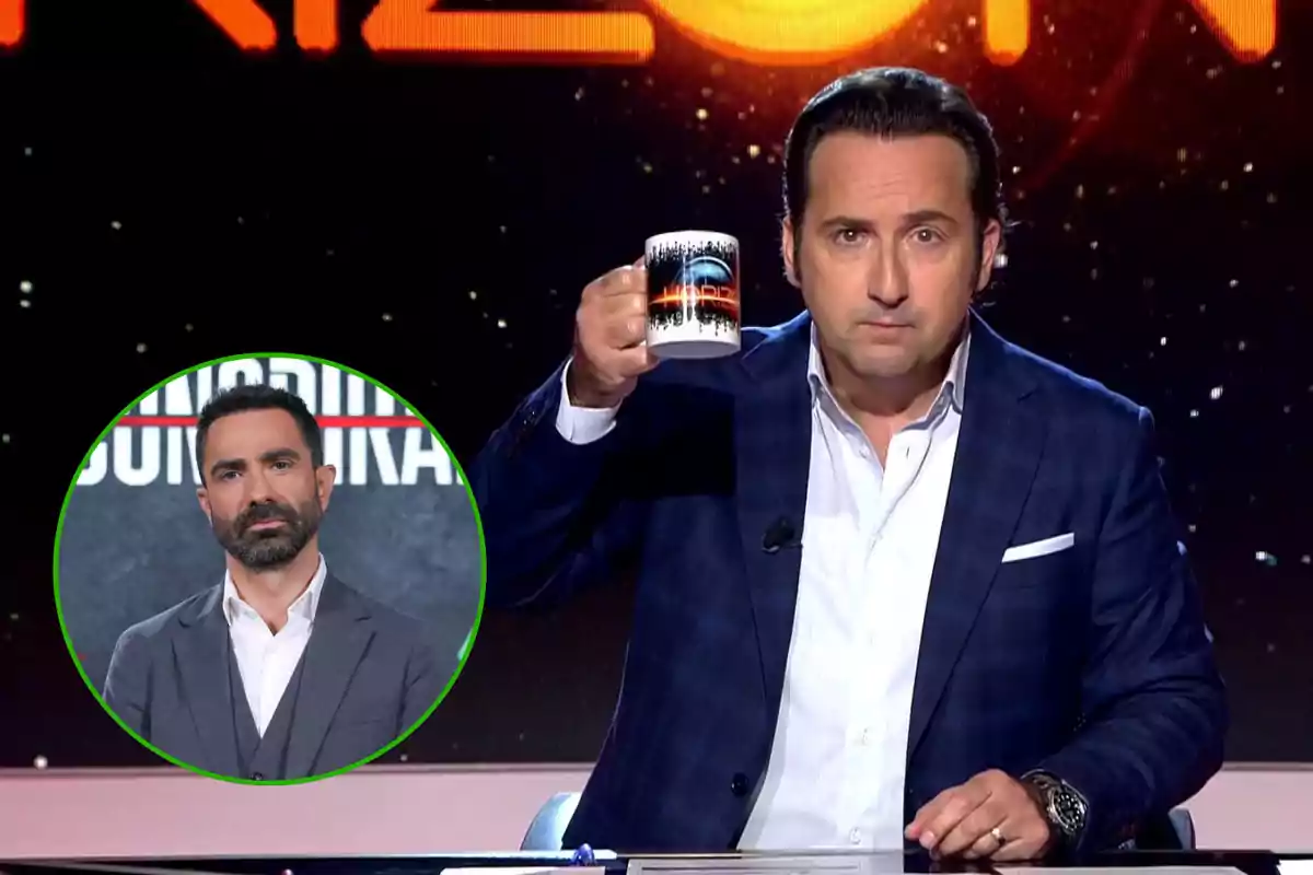 Un hombre en un set de televisión sosteniendo una taza con una imagen de fondo y un recuadro con otra persona en la esquina inferior izquierda.