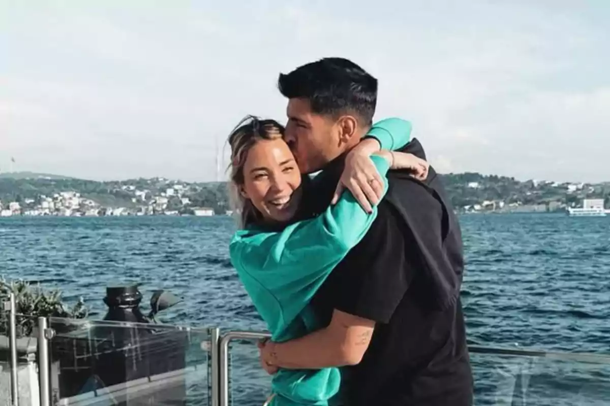 Alice Campello y Álvaro Morata abrazándose junto a un cuerpo de agua con un paisaje urbano al fondo. Alice Campello y Álvaro Morata abrazándose junto a un cuerpo de agua con un paisaje urbano al fondo.