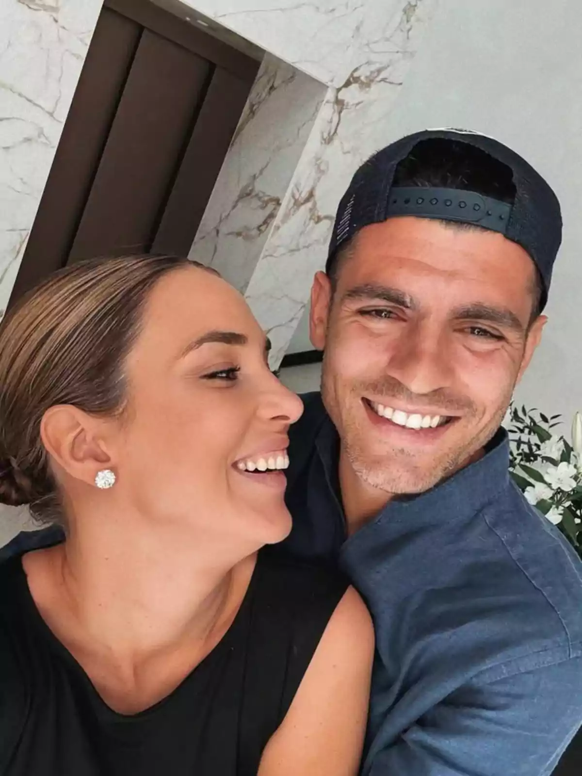 Alice Campello y Álvaro Morata sonriendo y abrazándose mientras se toman una selfie en un ambiente interior elegante Alice Campello y Álvaro Morata sonriendo y abrazándose mientras se toman una selfie en un ambiente interior elegante