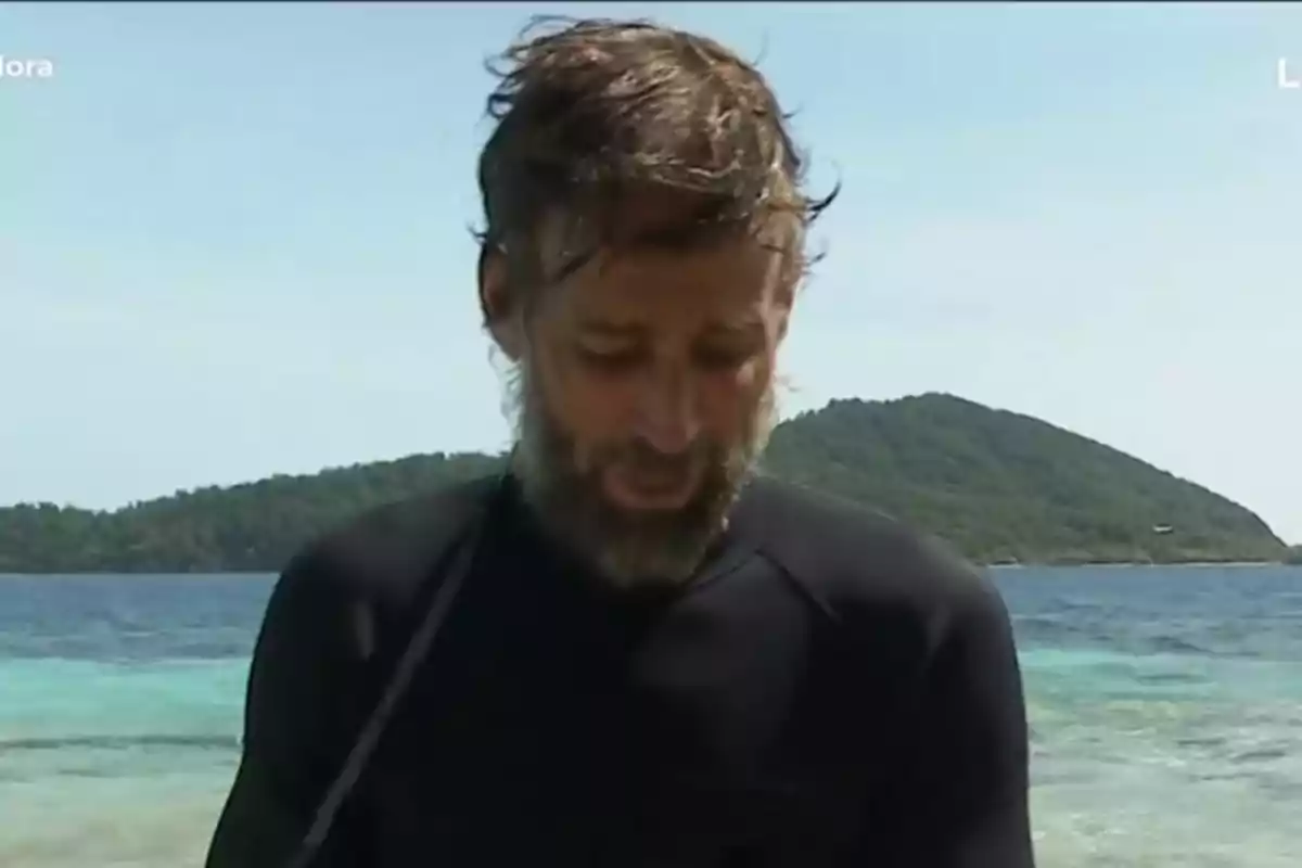 Álvaro Muñoz Escassi con barba y cabello despeinado vistiendo ropa oscura frente al mar con una isla al fondo Álvaro Muñoz Escassi con barba y cabello despeinado vistiendo ropa oscura frente al mar con una isla al fondo