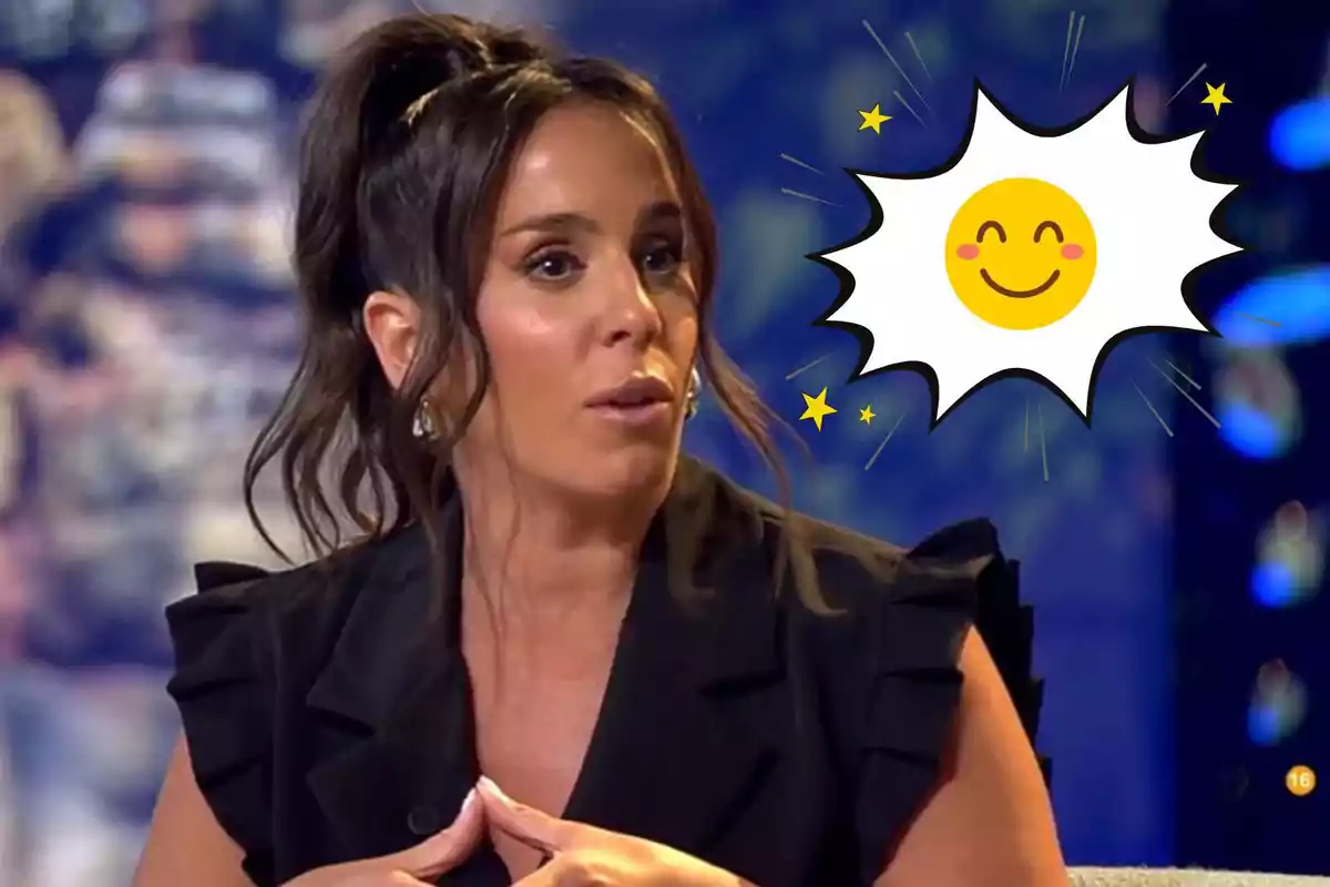 Anabel Pantoja con cabello oscuro y recogido está sentada en un programa de televisión con un gráfico de sol sonriente y estrellas a su lado.