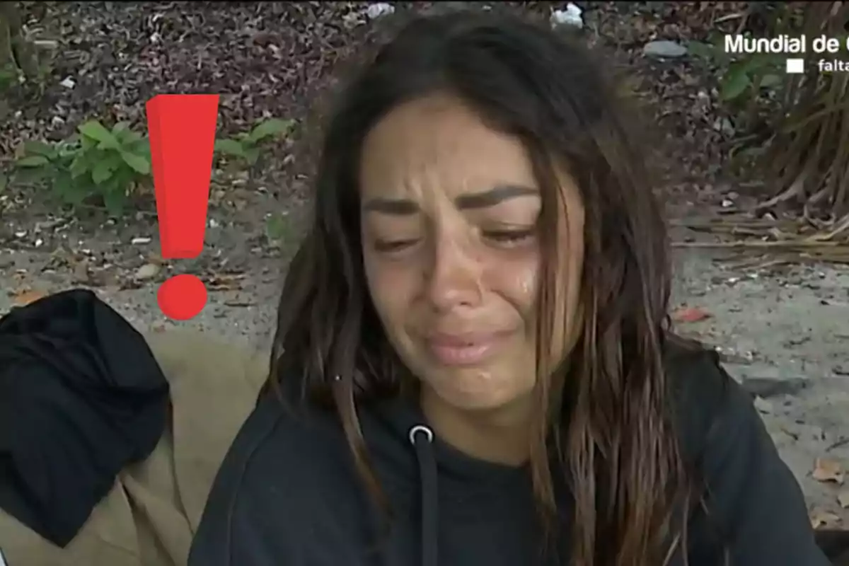 Anita Williams con expresión de tristeza llorando al aire libre junto a un gran signo de exclamación rojo