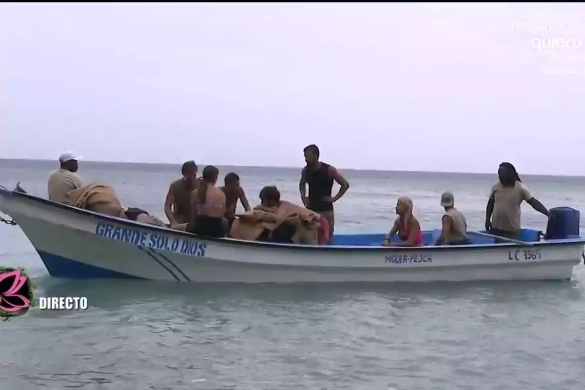 Varias personas están sentadas en una lancha blanca sobre el mar, algunas llevan ropa de playa y la embarcación tiene el nombre Grande Solo Dios escrito en el costado. Varias personas están sentadas en una lancha blanca sobre el mar, algunas llevan ropa de playa y la embarcación tiene el nombre Grande Solo Dios escrito en el costado.