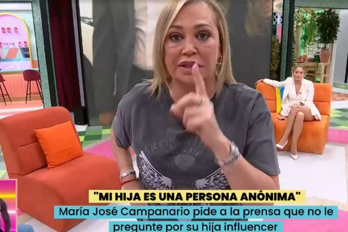 Belén Esteban en un plató de televisión hace un gesto con el dedo mientras otra persona está sentada en un sofá naranja al fondo. Belén Esteban en un plató de televisión hace un gesto con el dedo mientras otra persona está sentada en un sofá naranja al fondo.