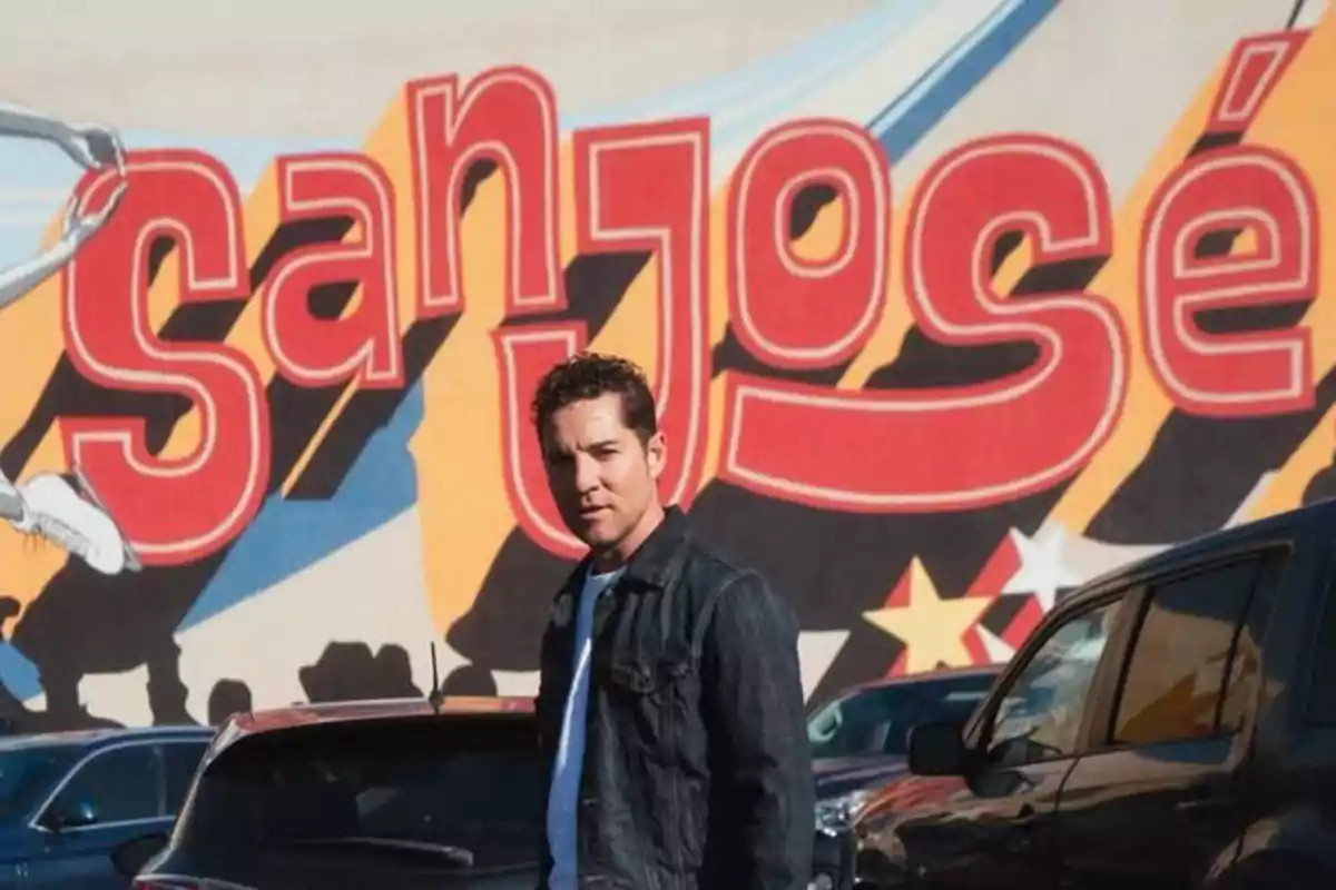 David Bisbal de pie frente a un mural colorido que dice David Bisbal de pie frente a un mural colorido que dice