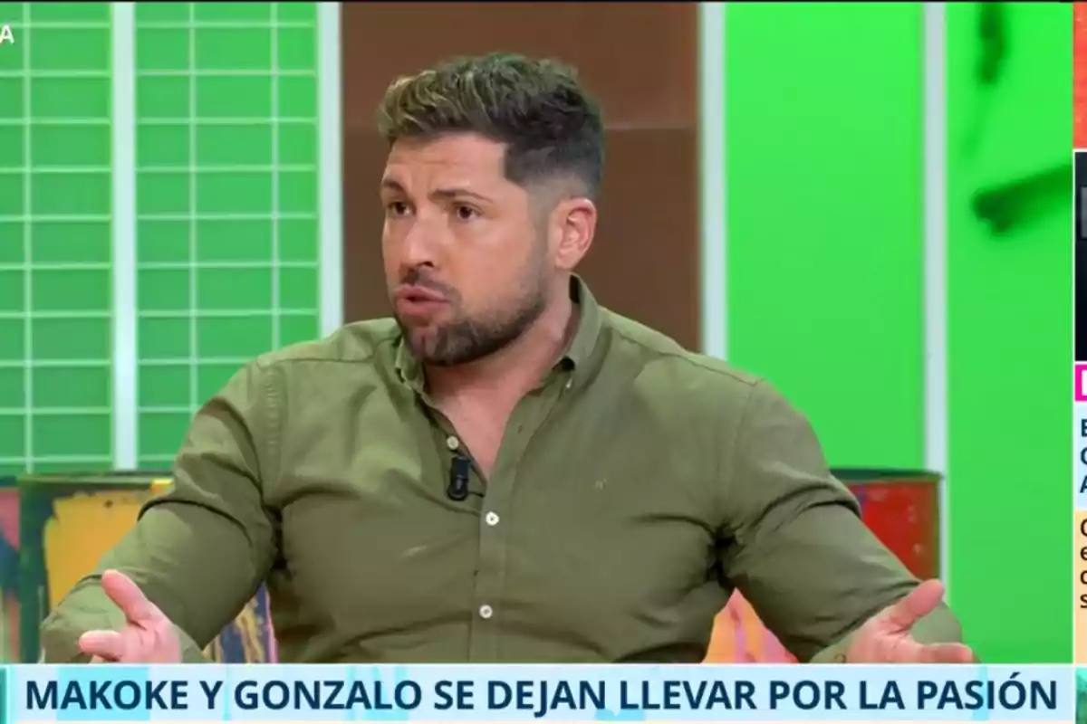 Kike Quintana con barba y camisa verde habla gesticulando en un programa de televisión con fondo verde y texto en la parte inferior. Kike Quintana con barba y camisa verde habla gesticulando en un programa de televisión con fondo verde y texto en la parte inferior.