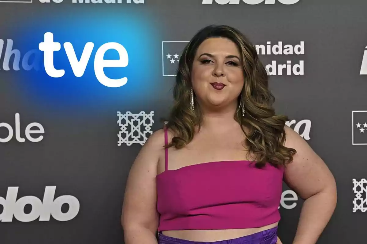 Lala Chus con vestido fucsia posa frente a un fondo con logotipos de TVE y Comunidad de Madrid.