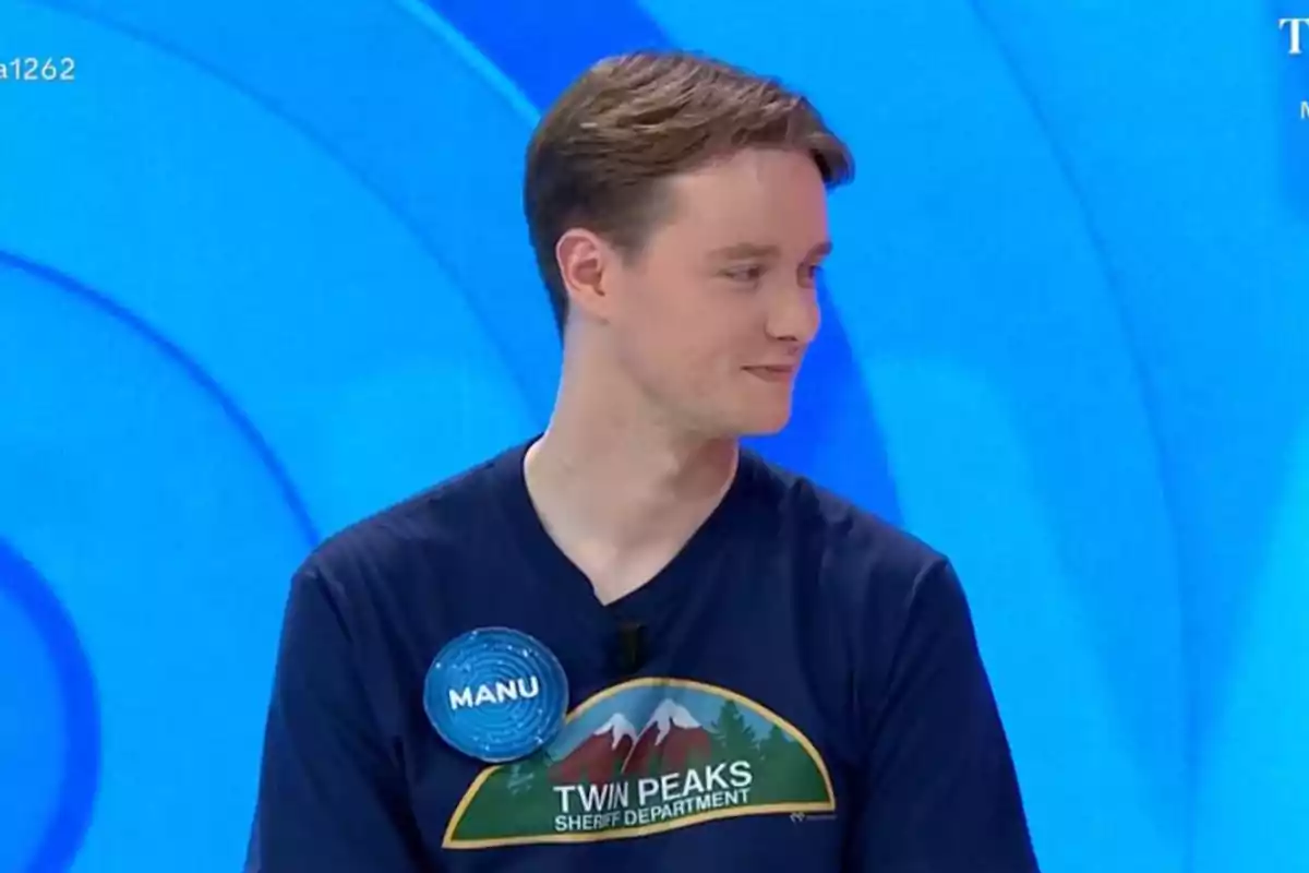 Manu con una camiseta de Twin Peaks y una etiqueta que dice Manu con una camiseta de Twin Peaks y una etiqueta que dice