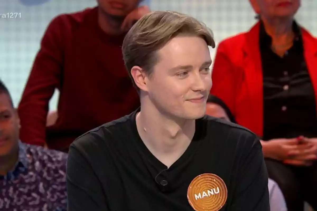 Manu joven con una camiseta negra y una etiqueta que dice Manu joven con una camiseta negra y una etiqueta que dice