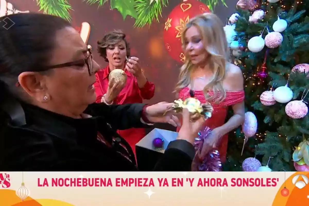 Un grupo de personas decora un árbol de Navidad con esferas y adornos festivos.