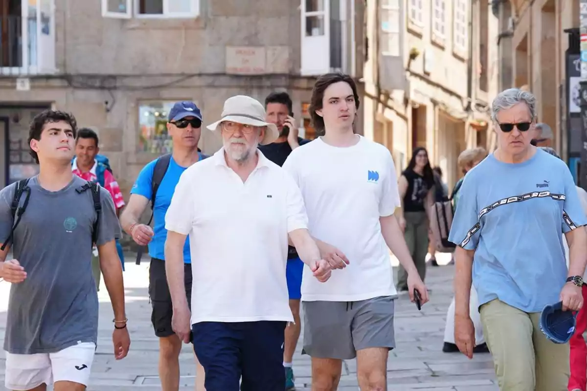 Grupo de personas caminando por una calle peatonal en una ciudad antigua en un día soleado Grupo de personas caminando por una calle peatonal en una ciudad antigua en un día soleado