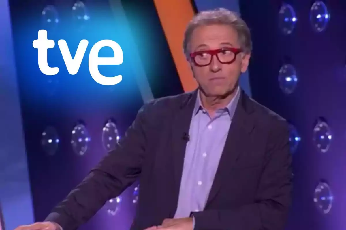 Jordi Hurtado con gafas rojas en un set de televisión con el logo de TVE en el fondo.