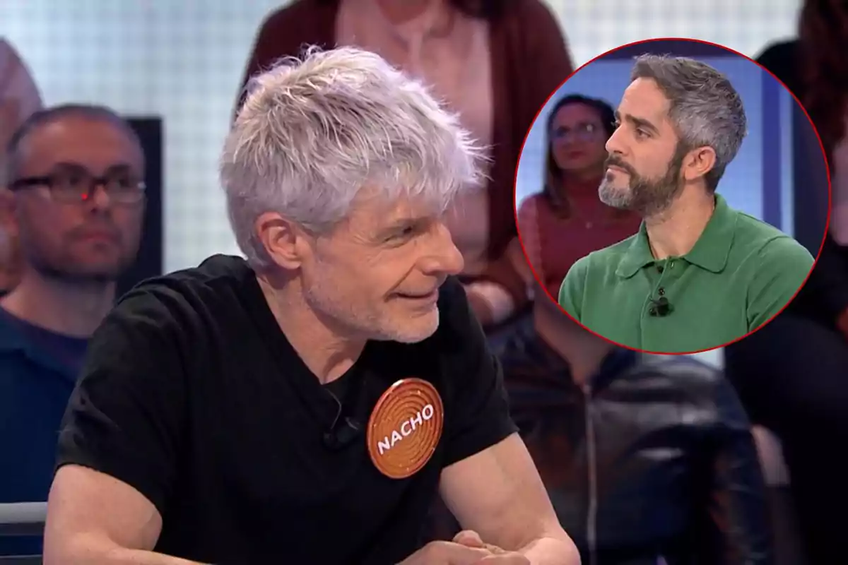 Nacho Guerreros de cabello canoso y camiseta negra con un distintivo que dice "Nacho" está sentado en un programa de televisión, mientras que en un recuadro se muestra a Roberto Leal con barba y camisa verde.