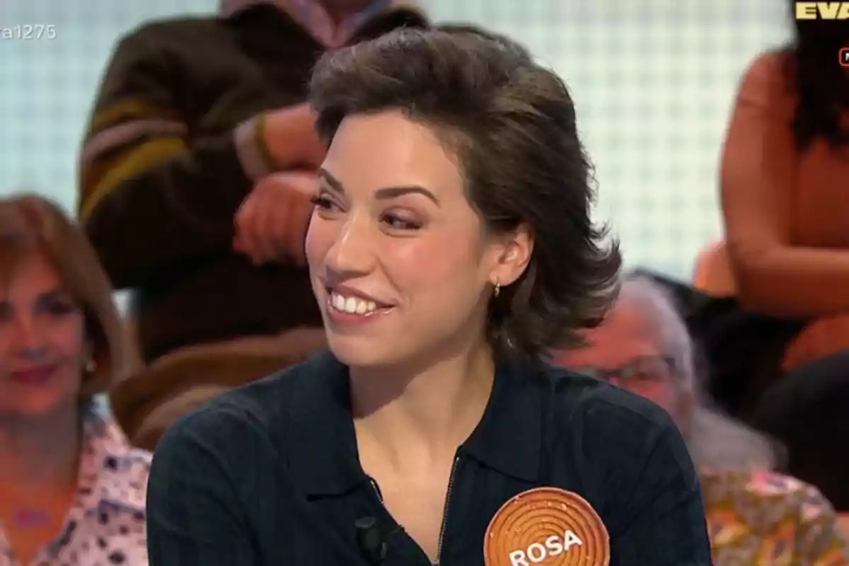 Rosa sonriente con cabello corto y oscuro lleva una etiqueta con el nombre Rosa sonriente con cabello corto y oscuro lleva una etiqueta con el nombre