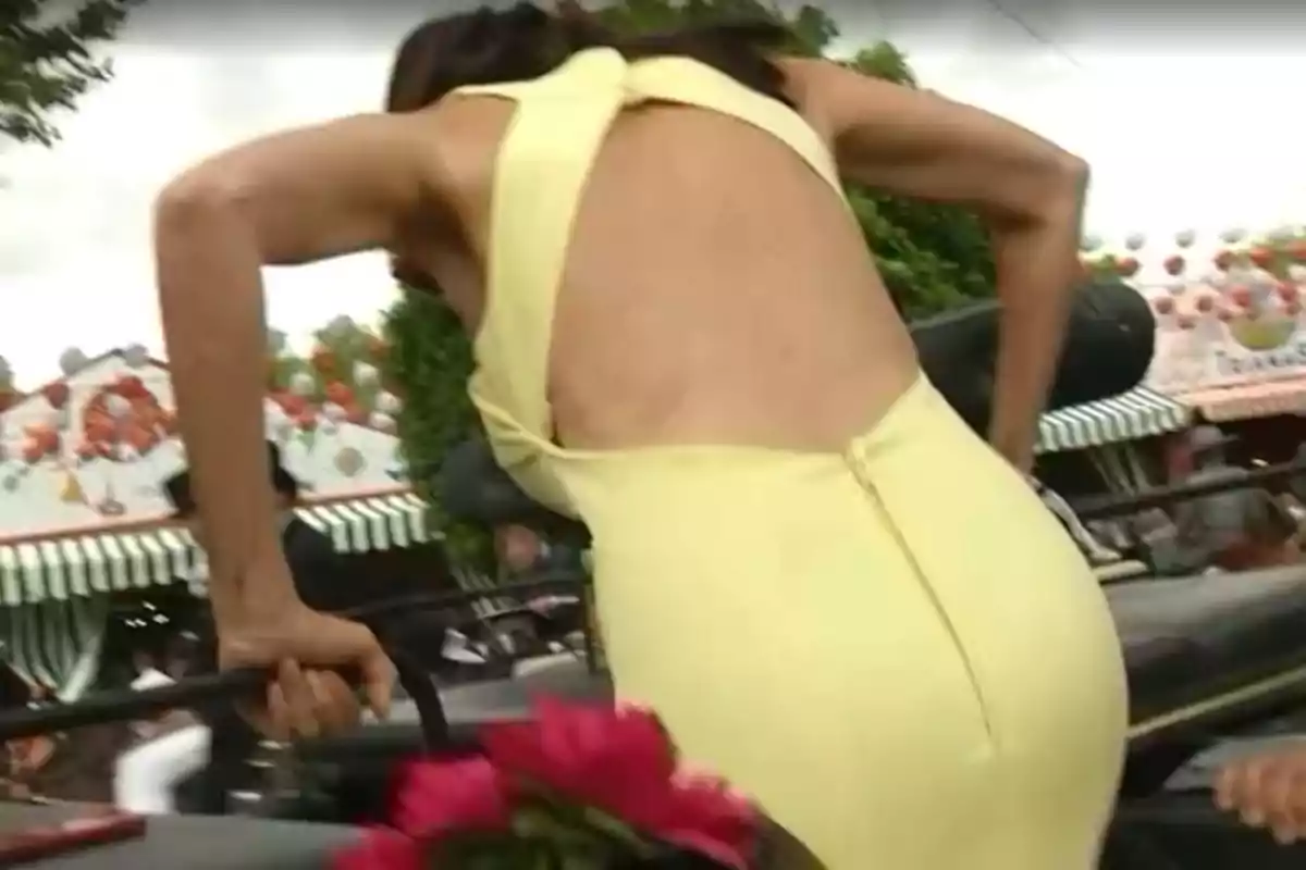 Paz Padilla con un vestido amarillo subiendo a un carruaje en un ambiente festivo con decoraciones y flores. Paz Padilla con un vestido amarillo subiendo a un carruaje en un ambiente festivo con decoraciones y flores.