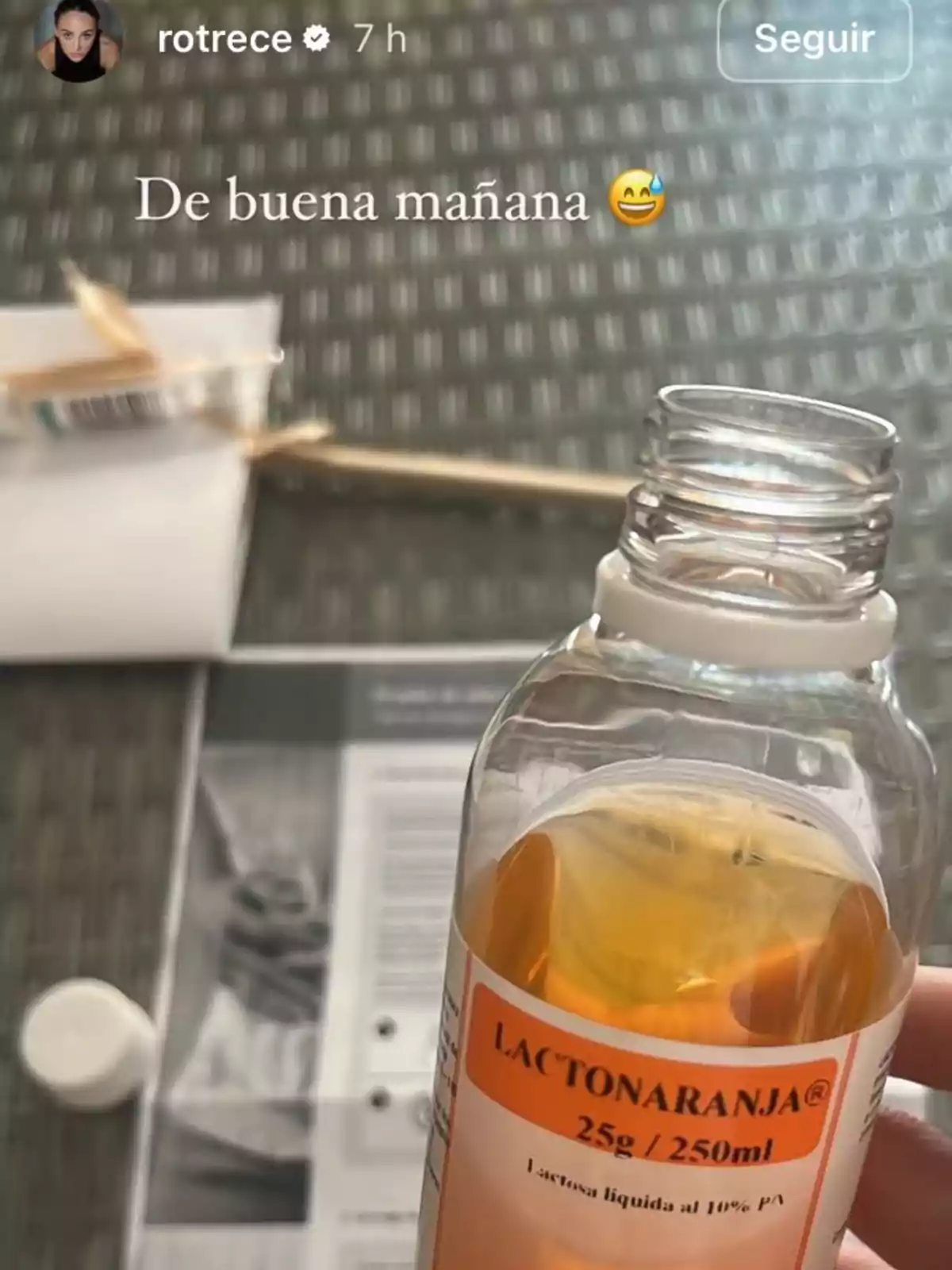 Una mano sostiene una botella de lactosa líquida al 10% con la etiqueta Una mano sostiene una botella de lactosa líquida al 10% con la etiqueta