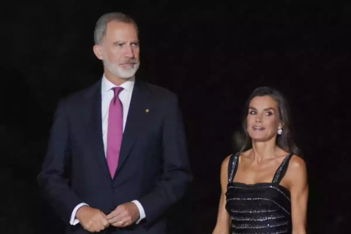 El rey Felipe VI y la reina Letizia elegantemente vestida camina junta en un evento nocturno. El rey Felipe VI y la reina Letizia elegantemente vestida camina junta en un evento nocturno.
