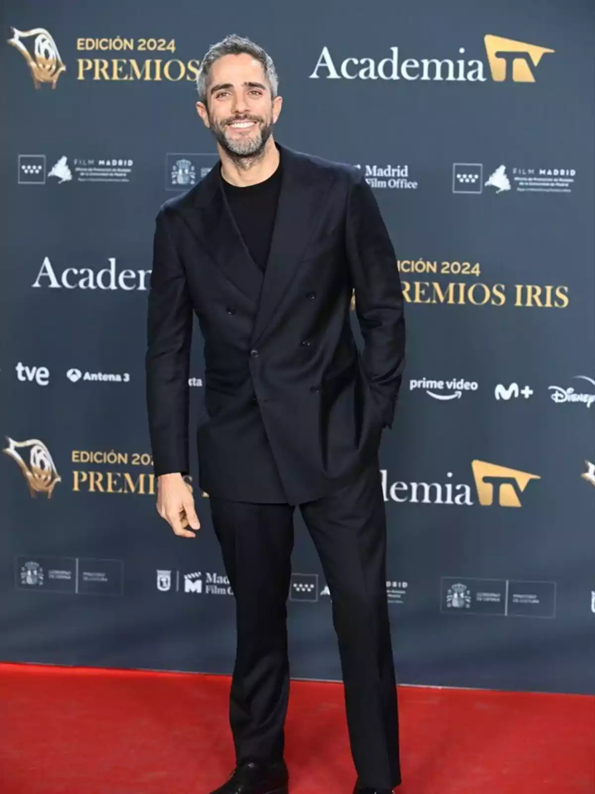 Smiling man on the red carpet of the 2024 Iris Awards, with the Television Academy logos in the background.