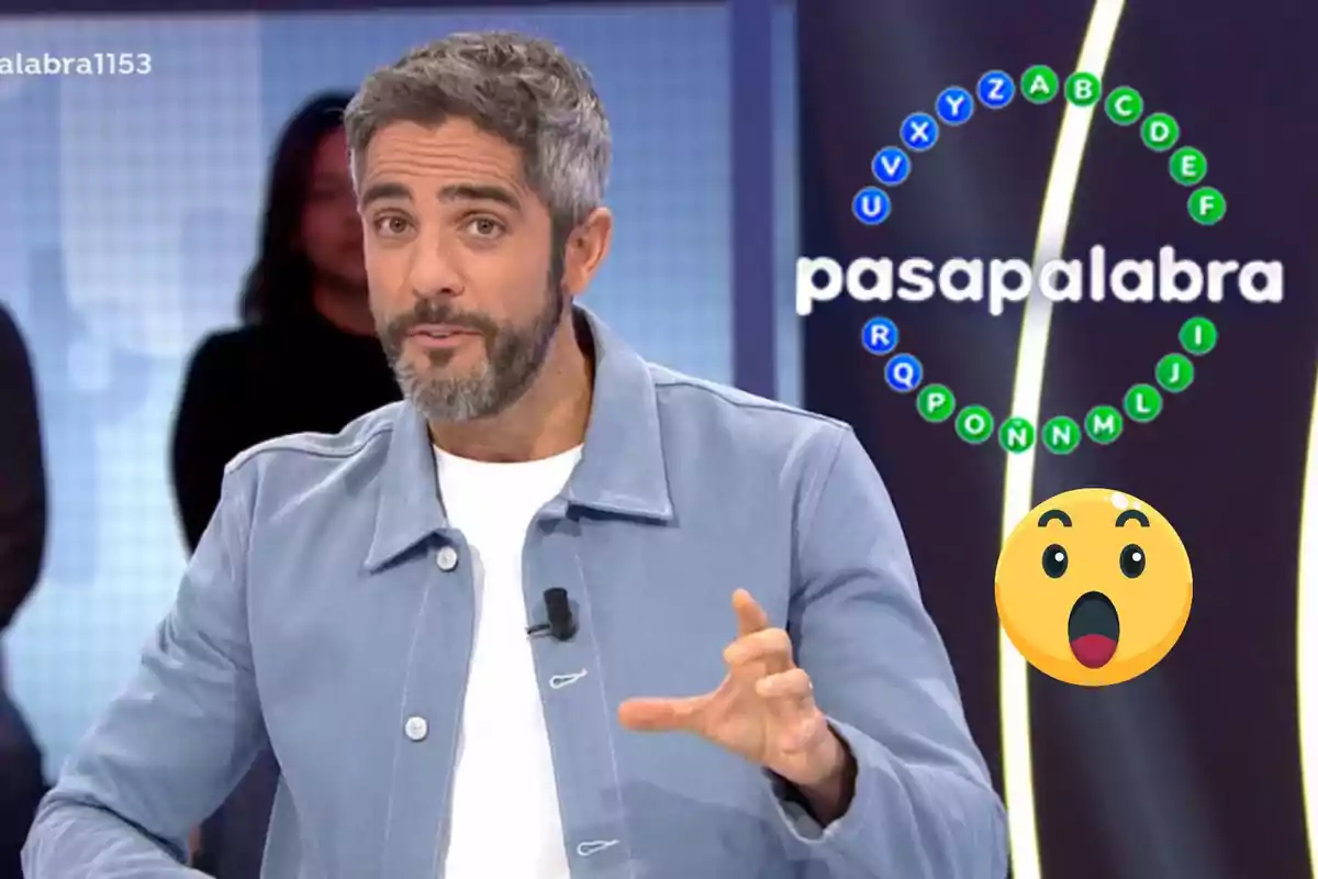 Roberto Leal con barba y cabello canoso está hablando en un set de un programa llamado "Pasapalabra" con un círculo de letras en el fondo y un emoji sorprendido.