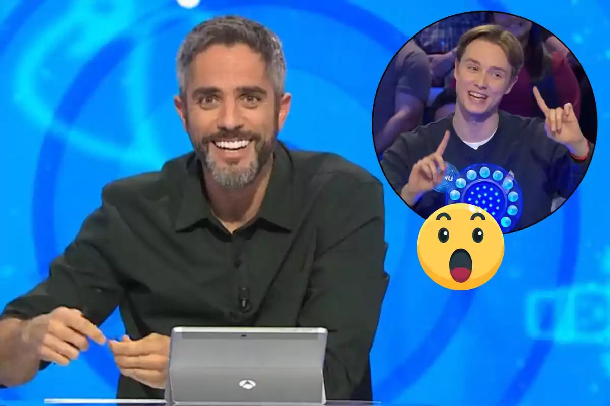 Roberto Leal sonriente en un programa de televisión con un círculo que muestra a Manu emocionado y un emoji sorprendido.