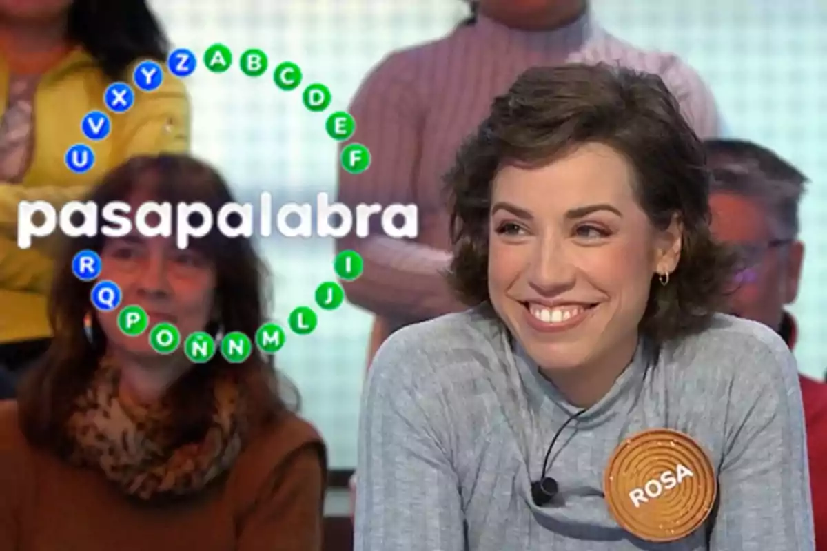 A contestant smiles on the TV show "Pasapalabra" while holding a sign with her name.