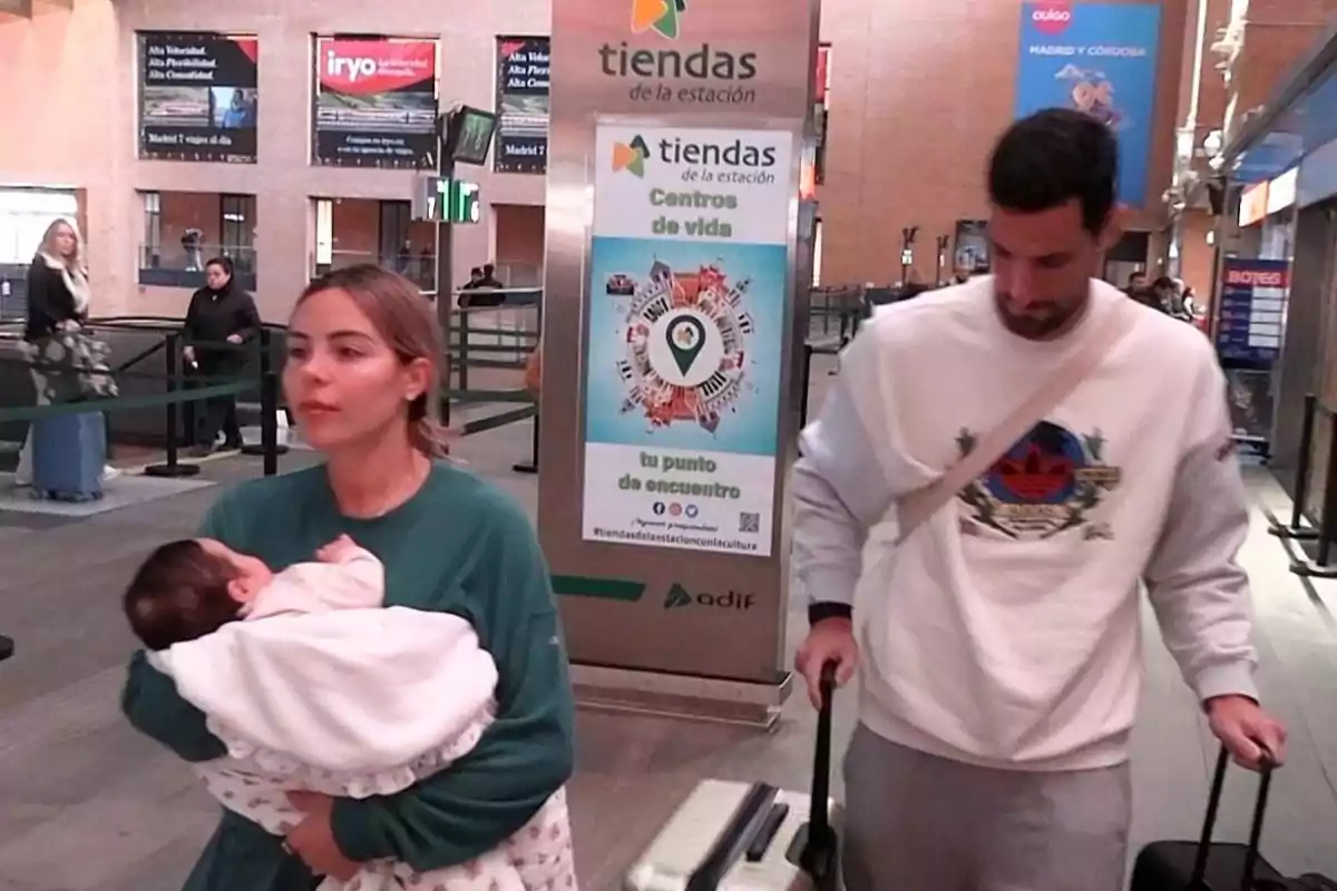 Alba Silva y Sergio Rico caminen en una estación de tren, Alba lleva a Carla en brazos y Sergio arrastra una maleta. Alba Silva y Sergio Rico caminen en una estación de tren, Alba lleva a Carla en brazos y Sergio arrastra una maleta.
