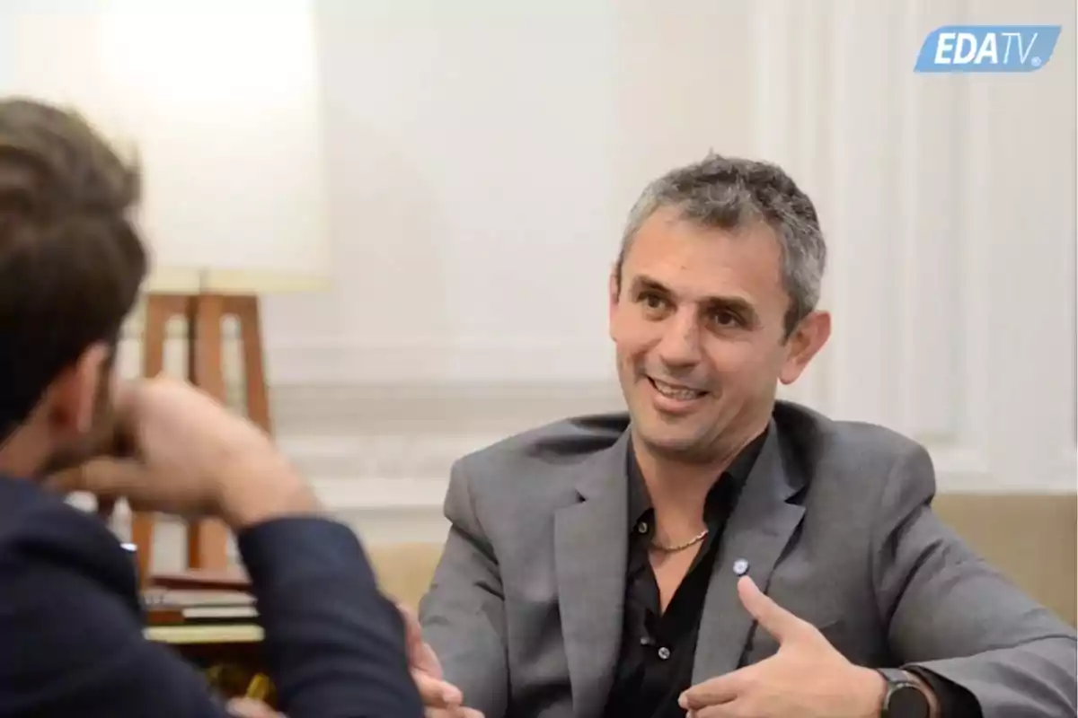 Dos hombres conversando en una entrevista en un estudio de televisión.