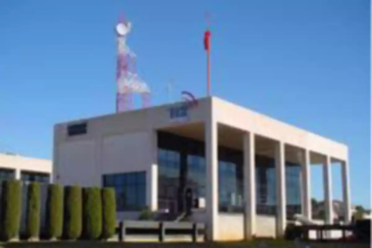 Modern building with antennas on the roof and clear sky.