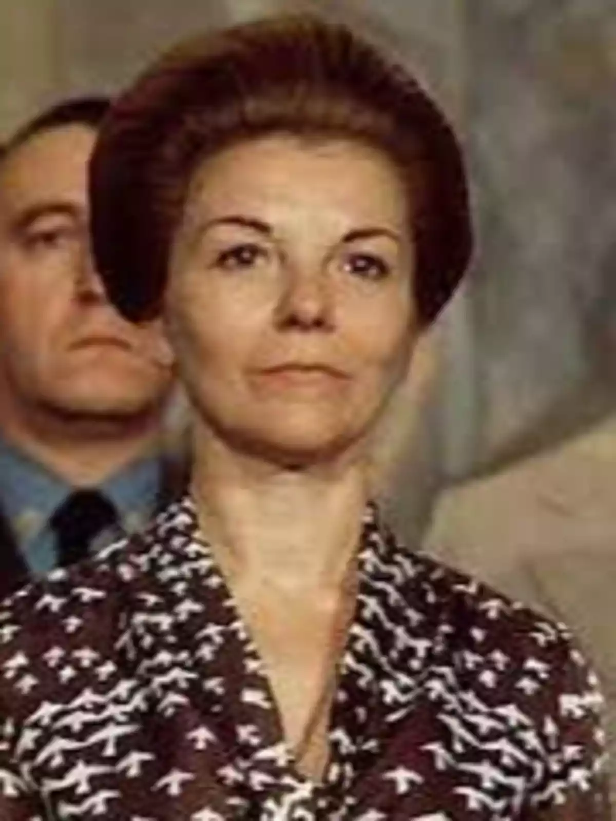 Una mujer con peinado alto y vestido con estampado de pájaros.