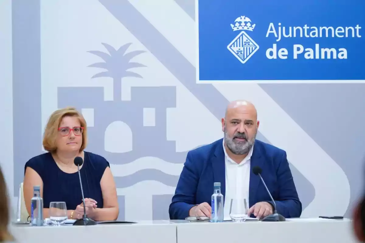 Dos personas sentadas en una mesa durante una conferencia de prensa en el Ayuntamiento de Palma.