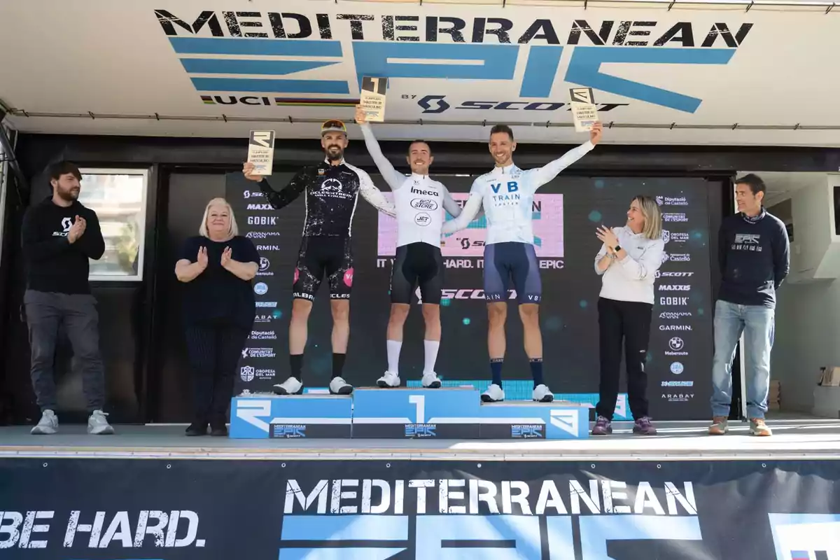 Cyclists on an awards podium during a cycling event, with people applauding the winners.