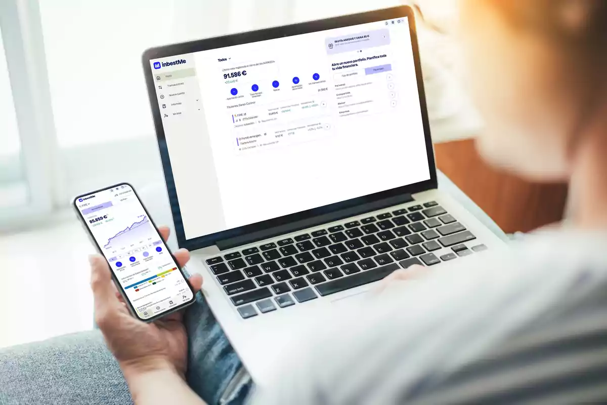 Persona usando una computadora portátil y un teléfono móvil para gestionar inversiones en la plataforma inbestMe.