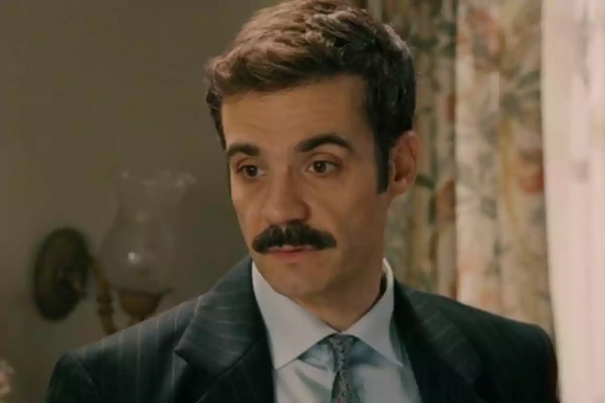 Javier Beltrán con bigote y traje oscuro en un ambiente interior. Javier Beltrán con bigote y traje oscuro en un ambiente interior.