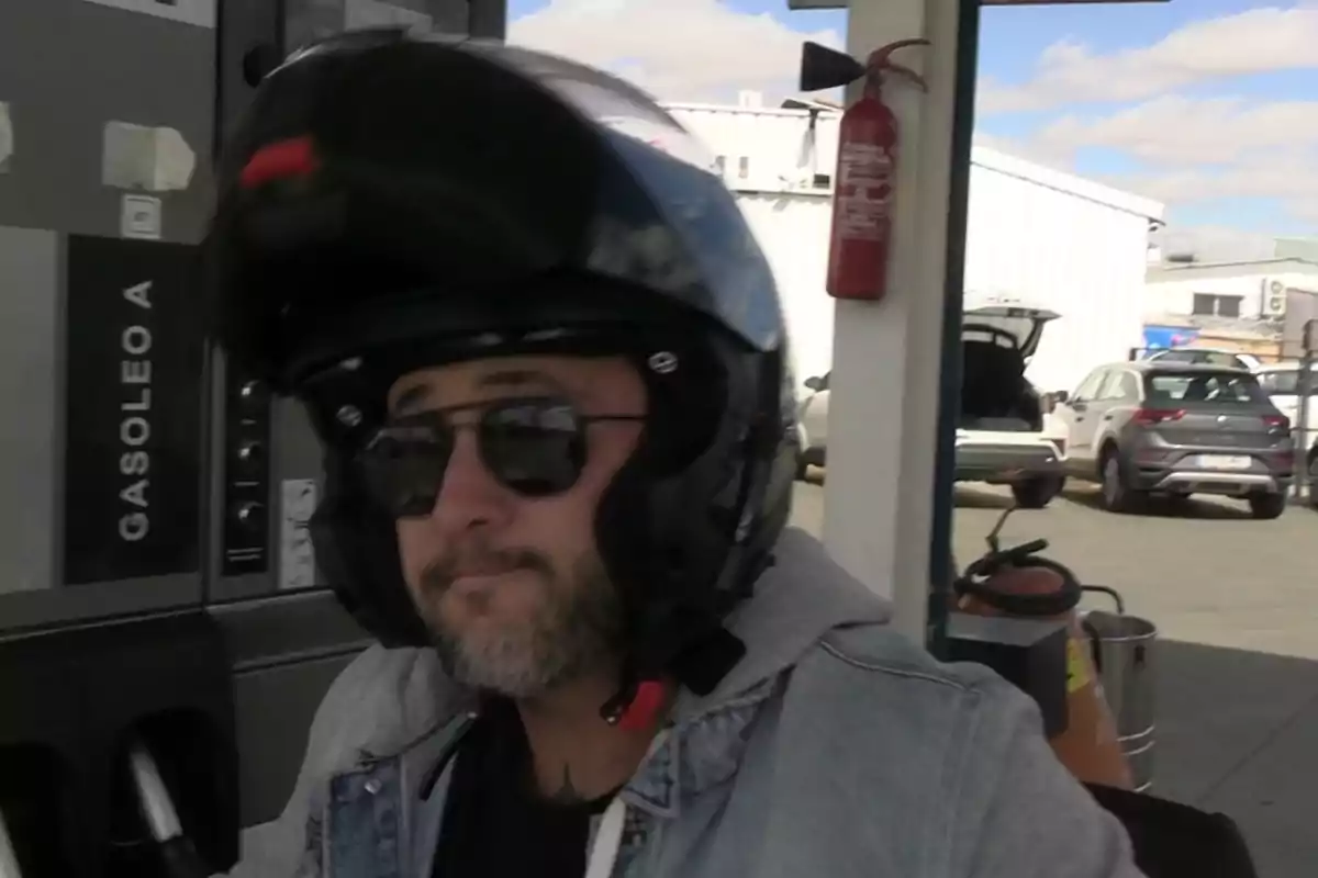 Foto de Kiko Rivera, con casco, gafas de sol y rostro serio, en una gasolinera siendo preguntado por un reportero de Europa Press sobre la muerte y la herencia de Julián Muñoz