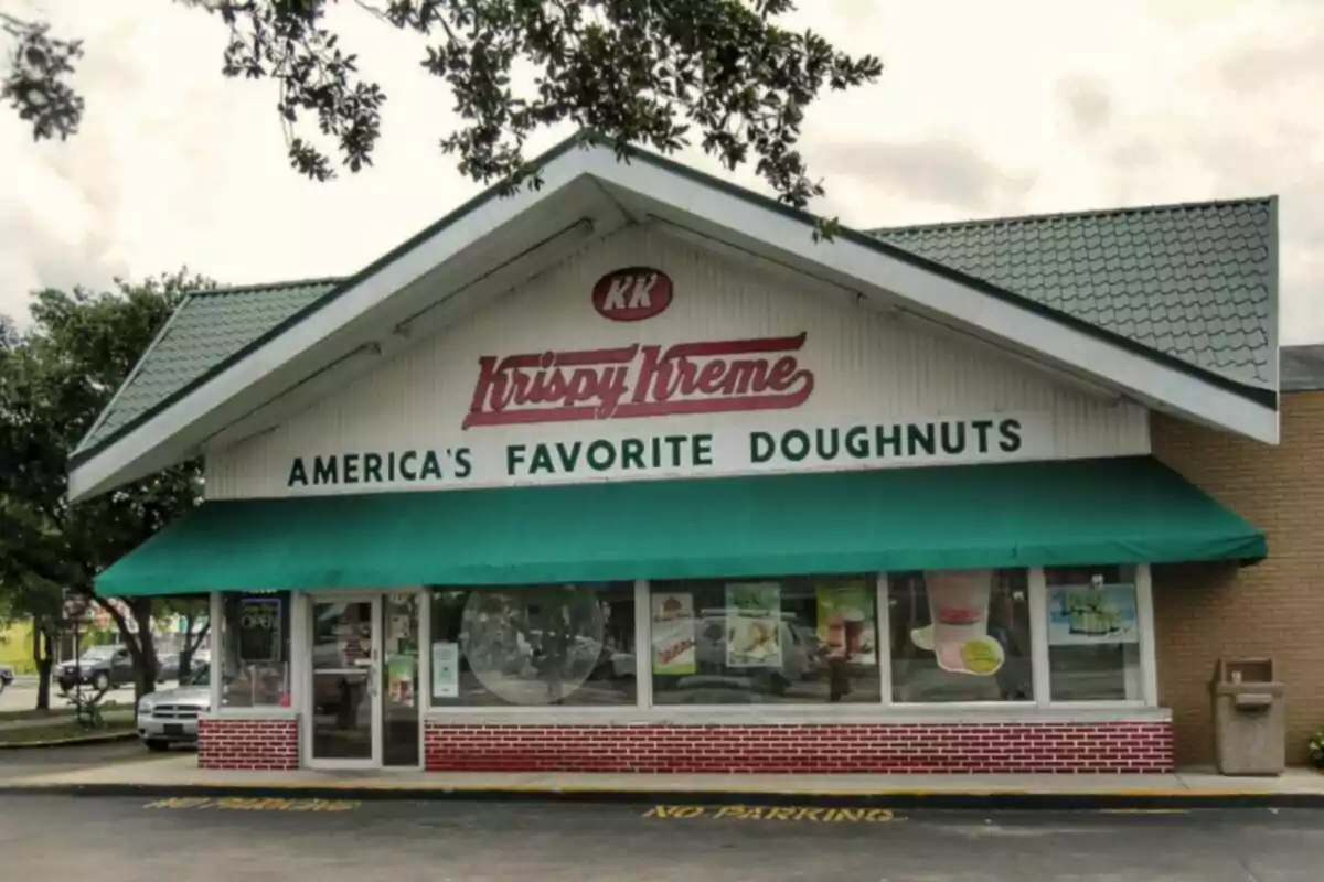 Fachada de una tienda Krispy Kreme con un letrero que dice Fachada de una tienda Krispy Kreme con un letrero que dice