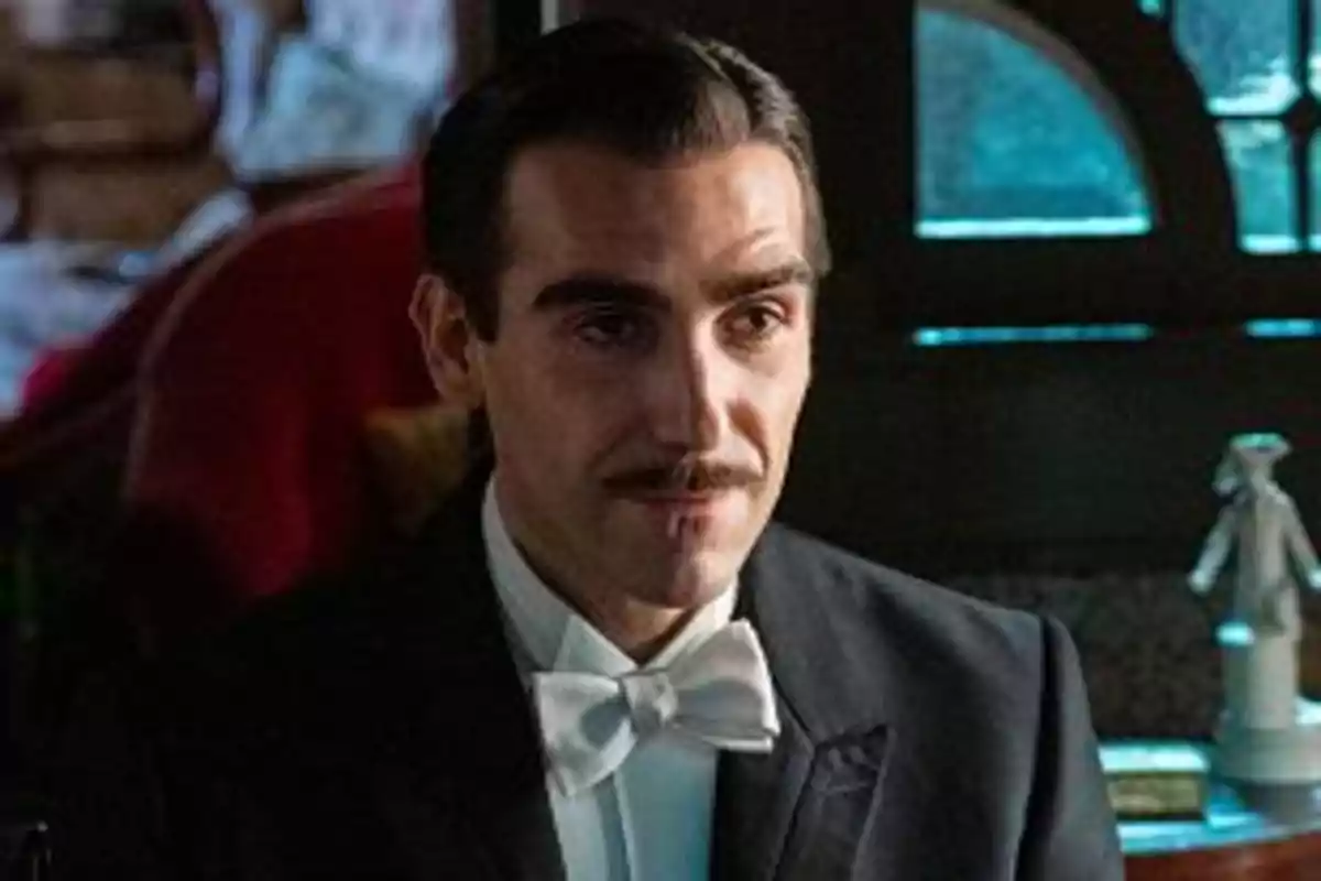 Lorenzo vestido con esmoquin y moño blanco sentado en un ambiente elegante. Captura de 'La Promesa' Lorenzo vestido con esmoquin y moño blanco sentado en un ambiente elegante. Captura de 'La Promesa'