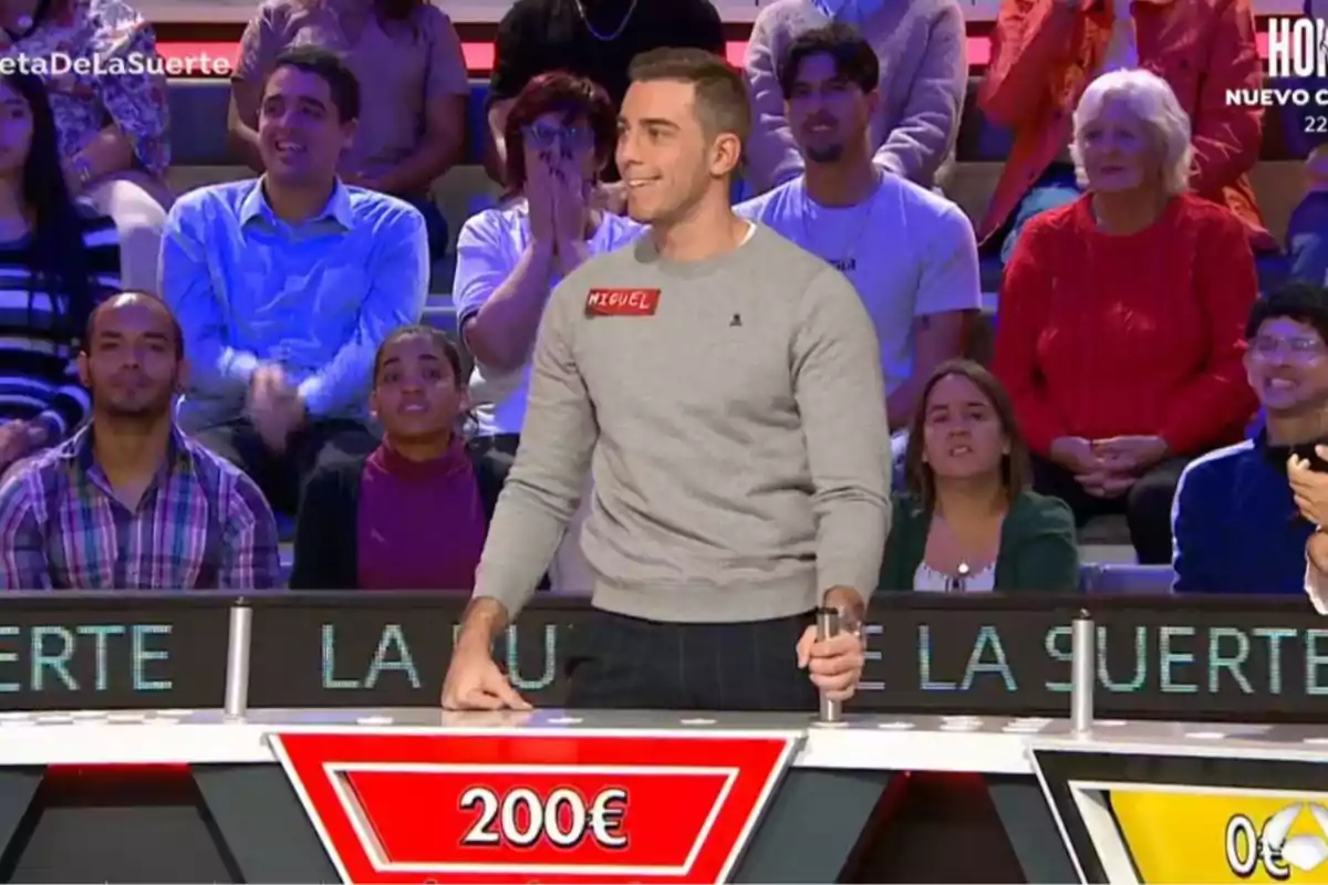 Miguel smiles as he takes part in a television show with an alert audience in the background. Screenshot from 'La ruleta de la Suerte'