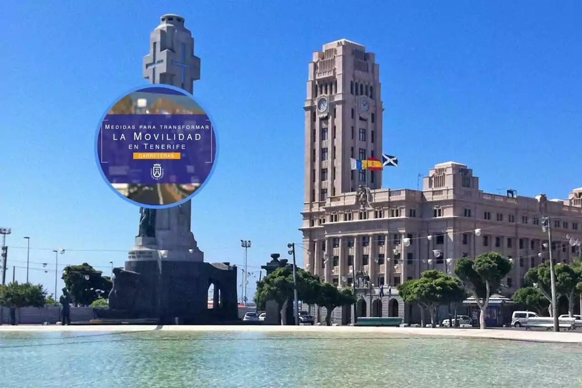 Una plaza con un monumento y un edificio grande al fondo, con un cielo despejado y una bandera ondeando.