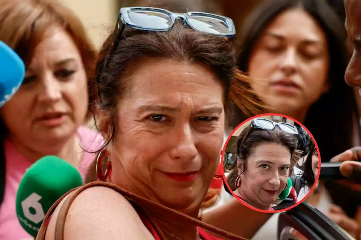 Mujer con gafas en la cabeza rodeada de periodistas y micrófonos mientras mira a la cámara con expresión seria y un recuadro ampliado de su rostro en la esquina inferior derecha