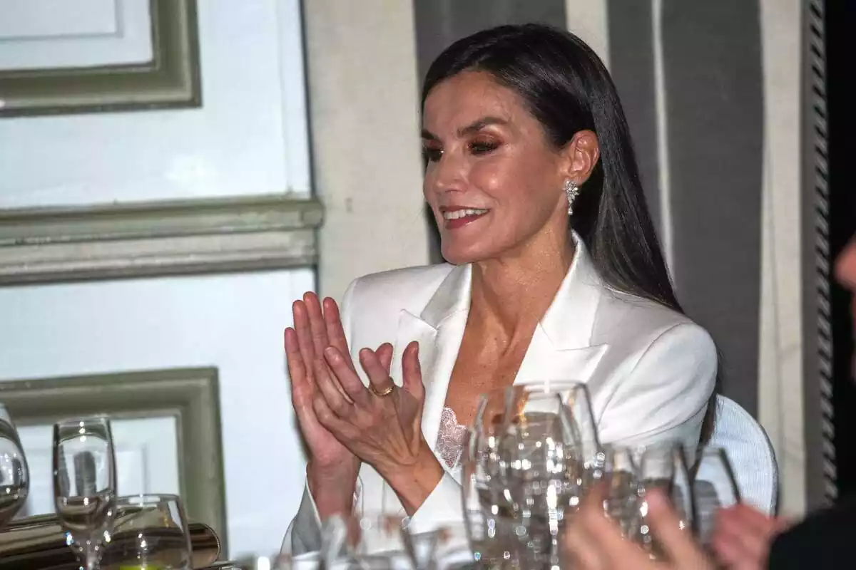 La reina Letizia con un traje blanco aplaudiendo sonriendo La reina Letizia con un traje blanco aplaudiendo sonriendo