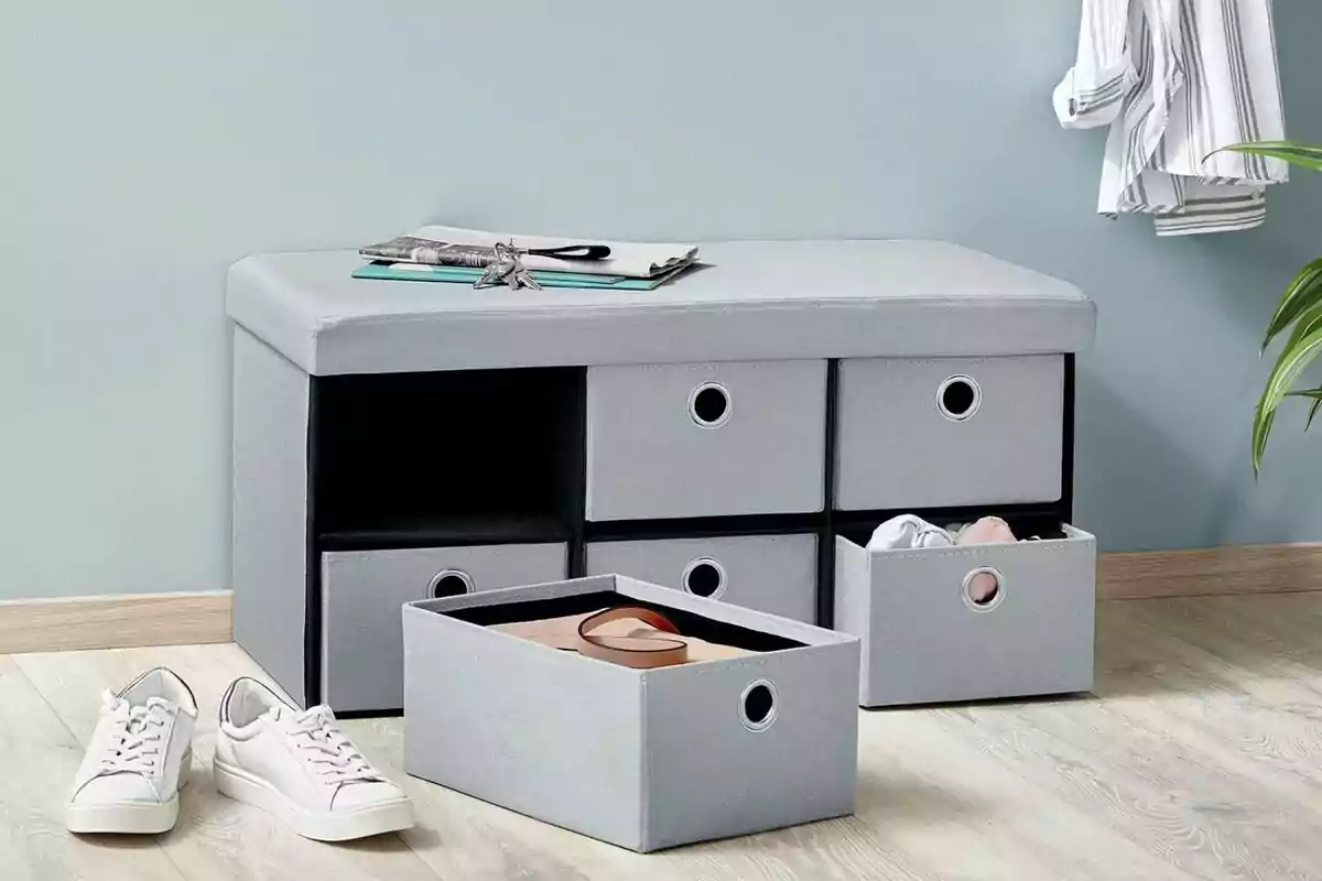Banco de almacenamiento gris con cajones y zapatos blancos en el suelo. Banco de almacenamiento gris con cajones y zapatos blancos en el suelo.