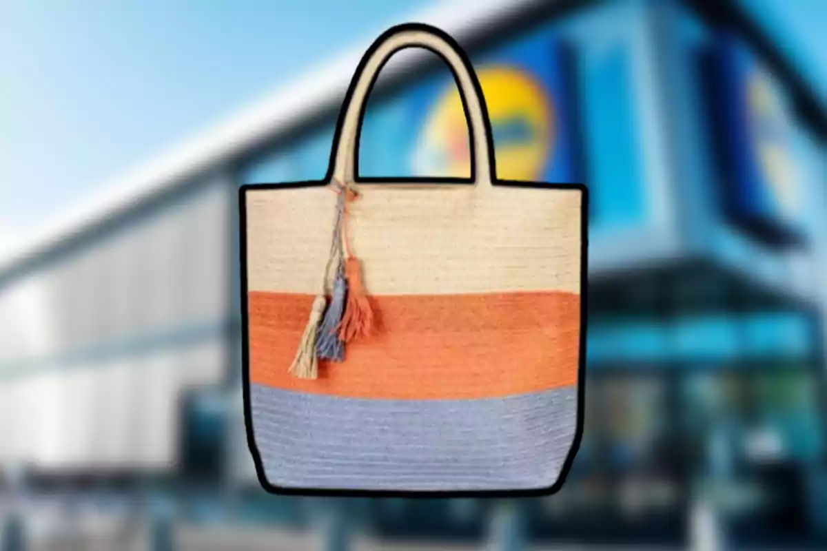 Bolso de paja con franjas horizontales en beige, naranja y azul, decorado con borlas, frente a un edificio borroso. Bolso de paja con franjas horizontales en beige, naranja y azul, decorado con borlas, frente a un edificio borroso.