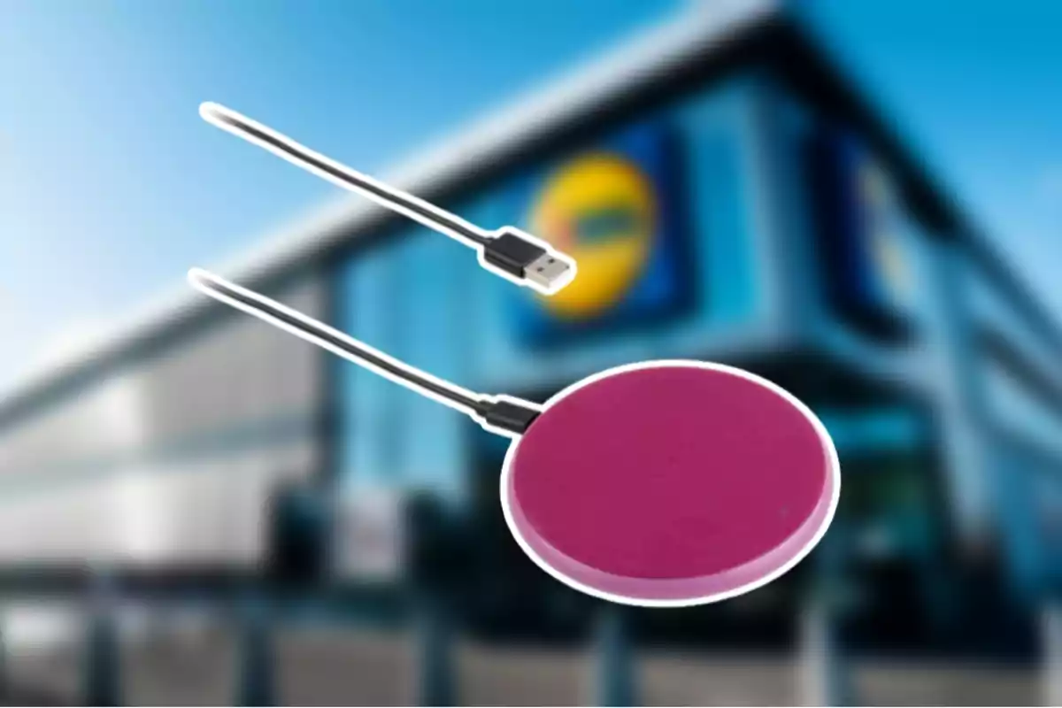 Un cargador inalámbrico de color rosa con un cable USB se muestra frente a un edificio desenfocado. Un cargador inalámbrico de color rosa con un cable USB se muestra frente a un edificio desenfocado.