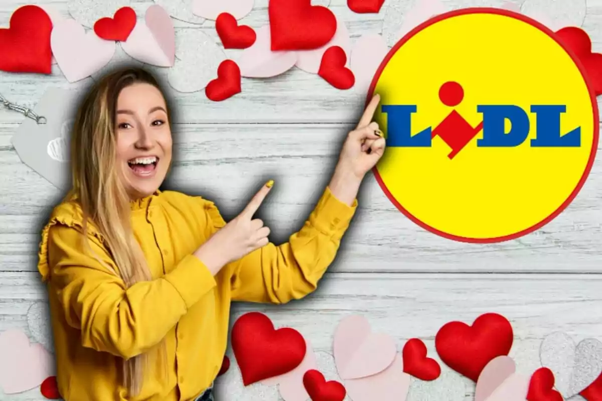 Una persona sonriente con una camisa amarilla señala el logotipo de Lidl rodeado de corazones rojos y rosados sobre un fondo de madera clara.