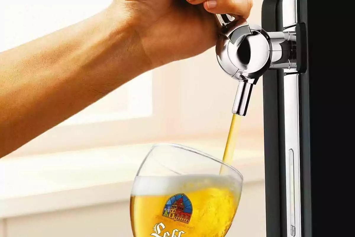 Mano sirviendo cerveza de un dispensador en un vaso. Mano sirviendo cerveza de un dispensador en un vaso.