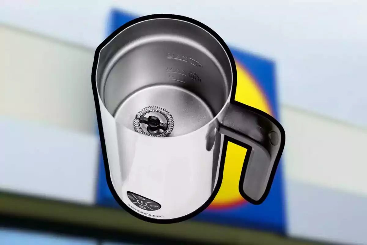 Taza de acero inoxidable con batidor eléctrico en el fondo de un logotipo borroso. Taza de acero inoxidable con batidor eléctrico en el fondo de un logotipo borroso.