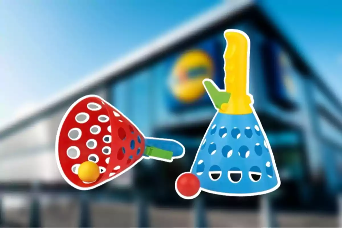 Juguetes de plástico con forma de canasta en colores rojo y azul con pelotas amarillas y rojas frente a un edificio borroso. Juguetes de plástico con forma de canasta en colores rojo y azul con pelotas amarillas y rojas frente a un edificio borroso.