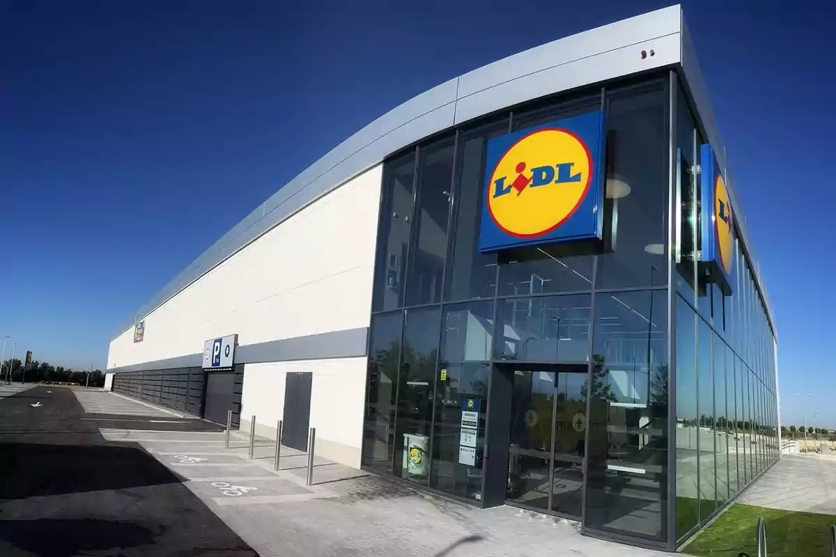 Lidl grande, de extrarradio, con paredes acristaladas por la parte de la tienda y, a la izquierda, la entrada al parking subterráneo con pared de hormigón.