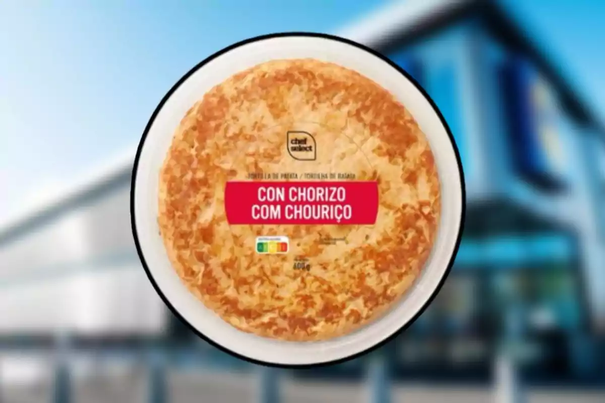 Envase de tortilla de patata con chorizo sobre un fondo desenfocado de un edificio. Envase de tortilla de patata con chorizo sobre un fondo desenfocado de un edificio.